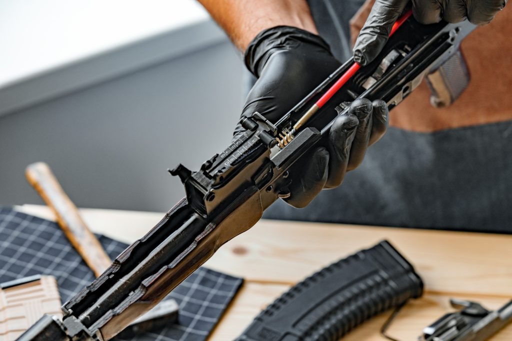Close up of a gunsmith cleaning firearm barrel with ramrod brush